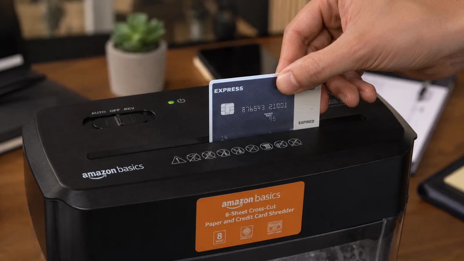 Close-up of an expired credit card being fed into the shredder's dedicated card slot