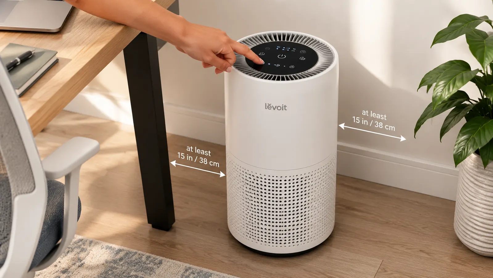 LEVOIT air purifier placed on the floor about two feet from a home office desk, away from the wall