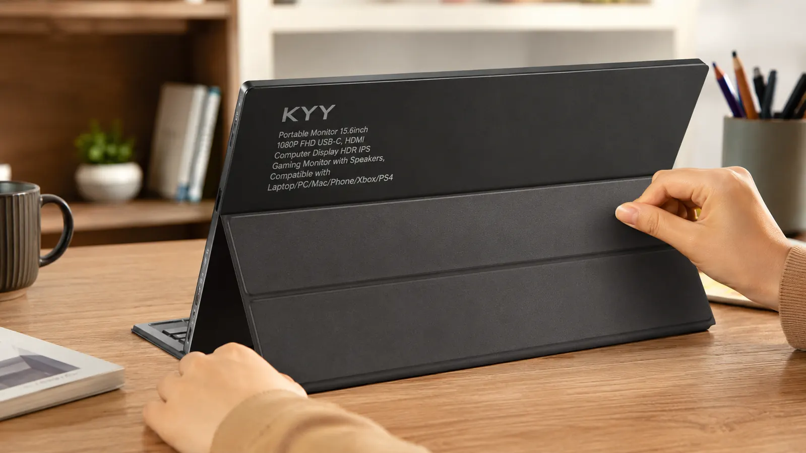 Close-up of a hand adjusting the folio kickstand angle on the back of the KYY portable monitor